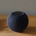 HomePod Mini preto sentado em uma mesa de madeira