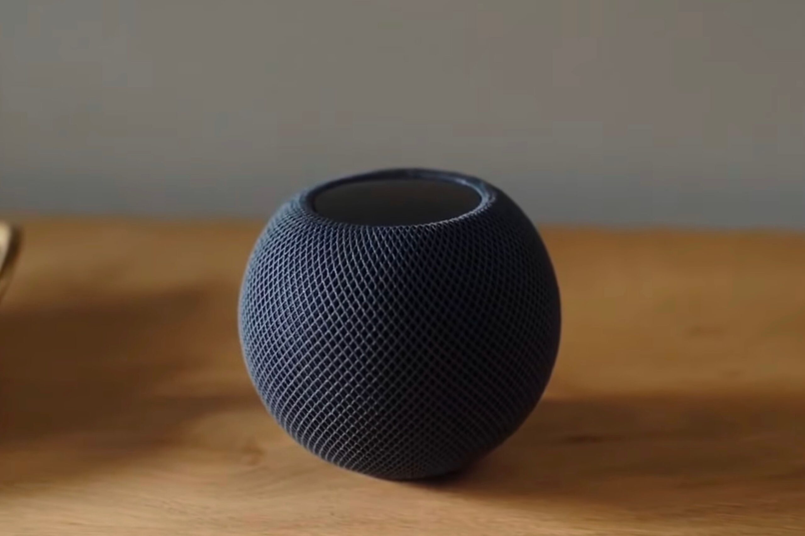 HomePod Mini preto sentado em uma mesa de madeira