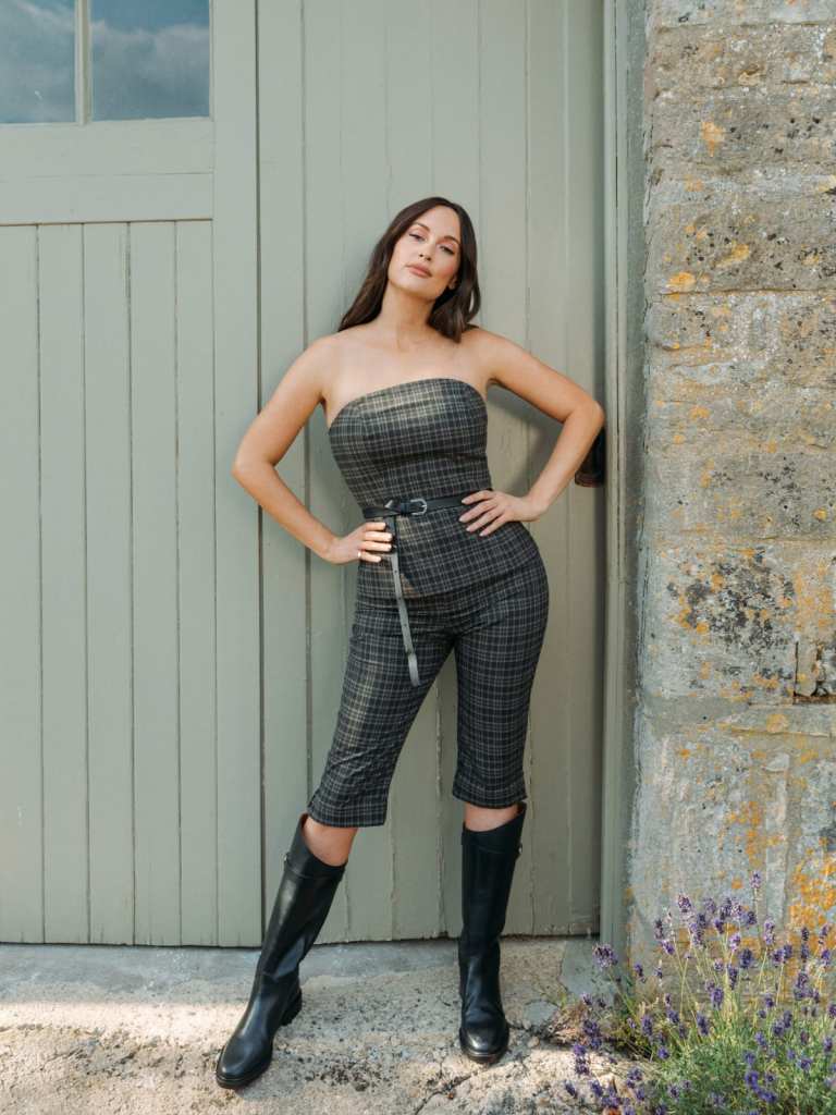 kacey musgraves vestindo top de algodão verde, marinho e preto com capris combinando e botas pretas