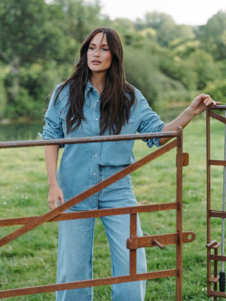 Kacey Musgraves usando blusa jeans com lavagem clara e jeans de perna larga combinando