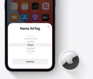 Uma AirTag ao lado de um iPhone.