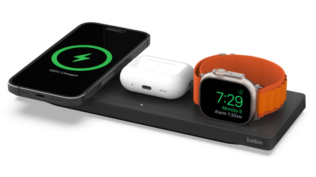 Smartphone, fones de ouvido sem fio e smartwatch com pulseira laranja em uma base de carregamento sem fio da Belkin.