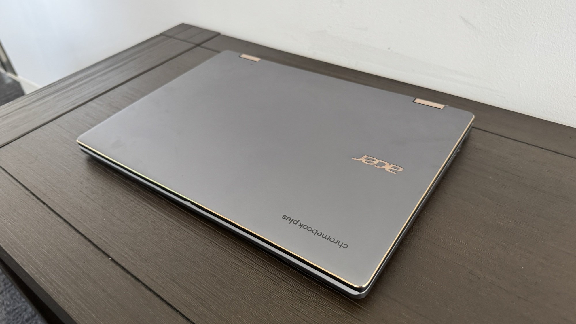 Um laptop Acer Chromebook Plus Spin 714 fechado em um banco de madeira