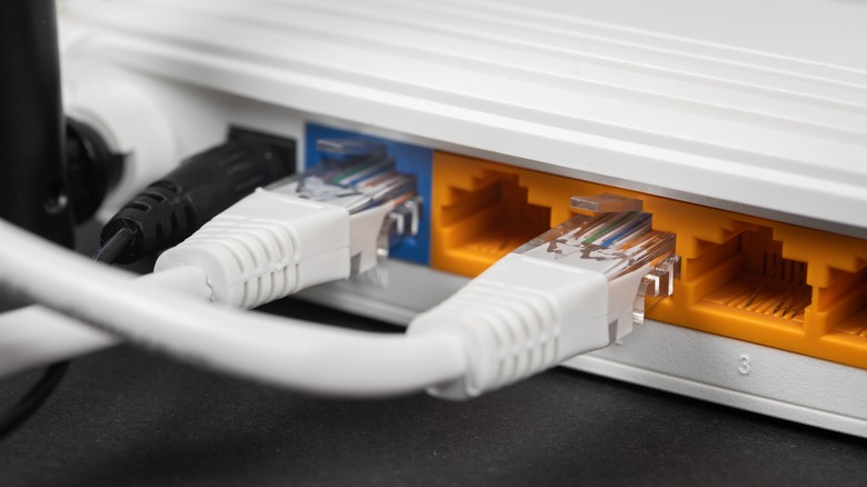 A parte traseira de um roteador mostrando os cabos Ethernet conectados