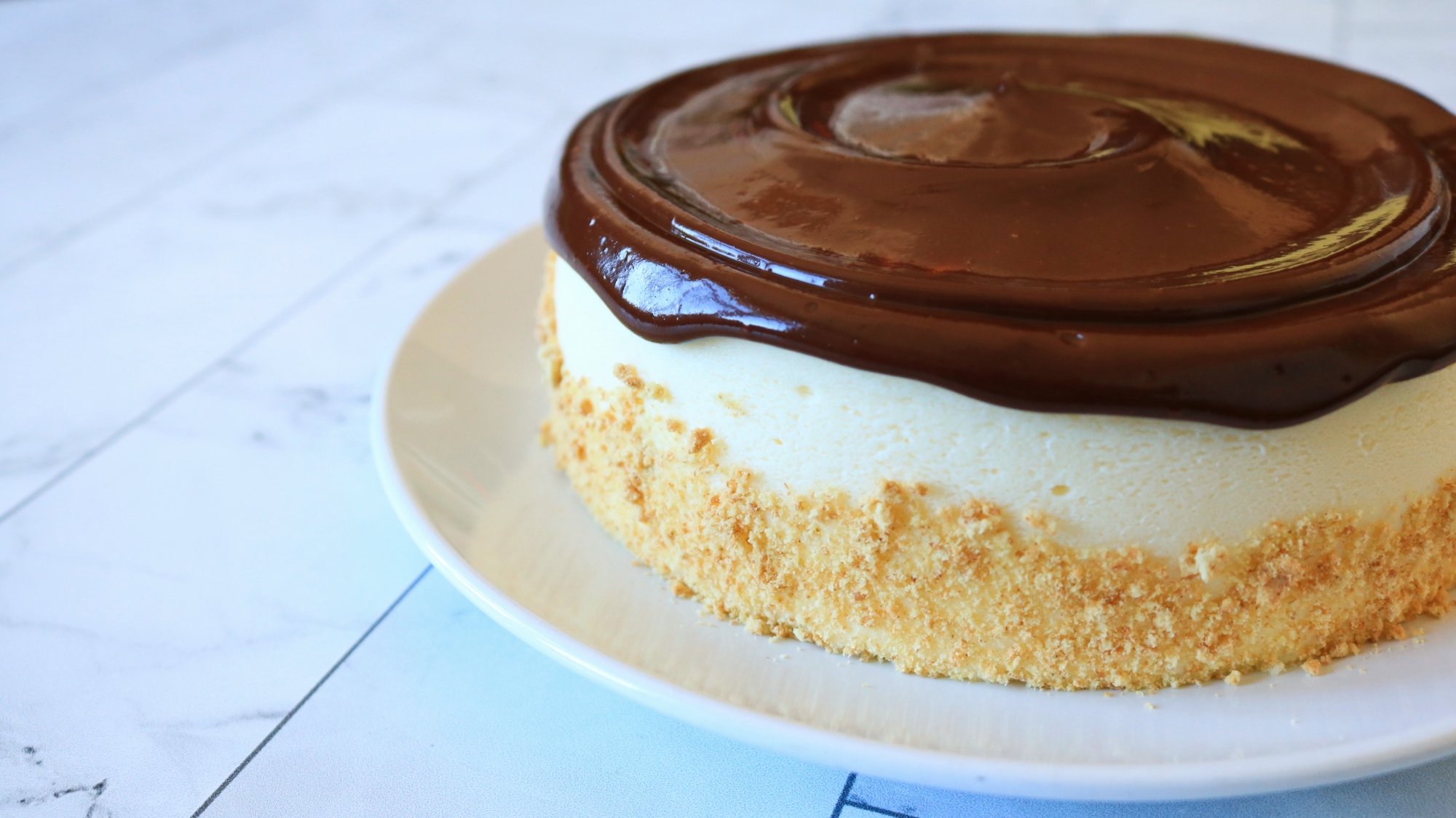 Cheesecake com ganache de chocolate por cima.