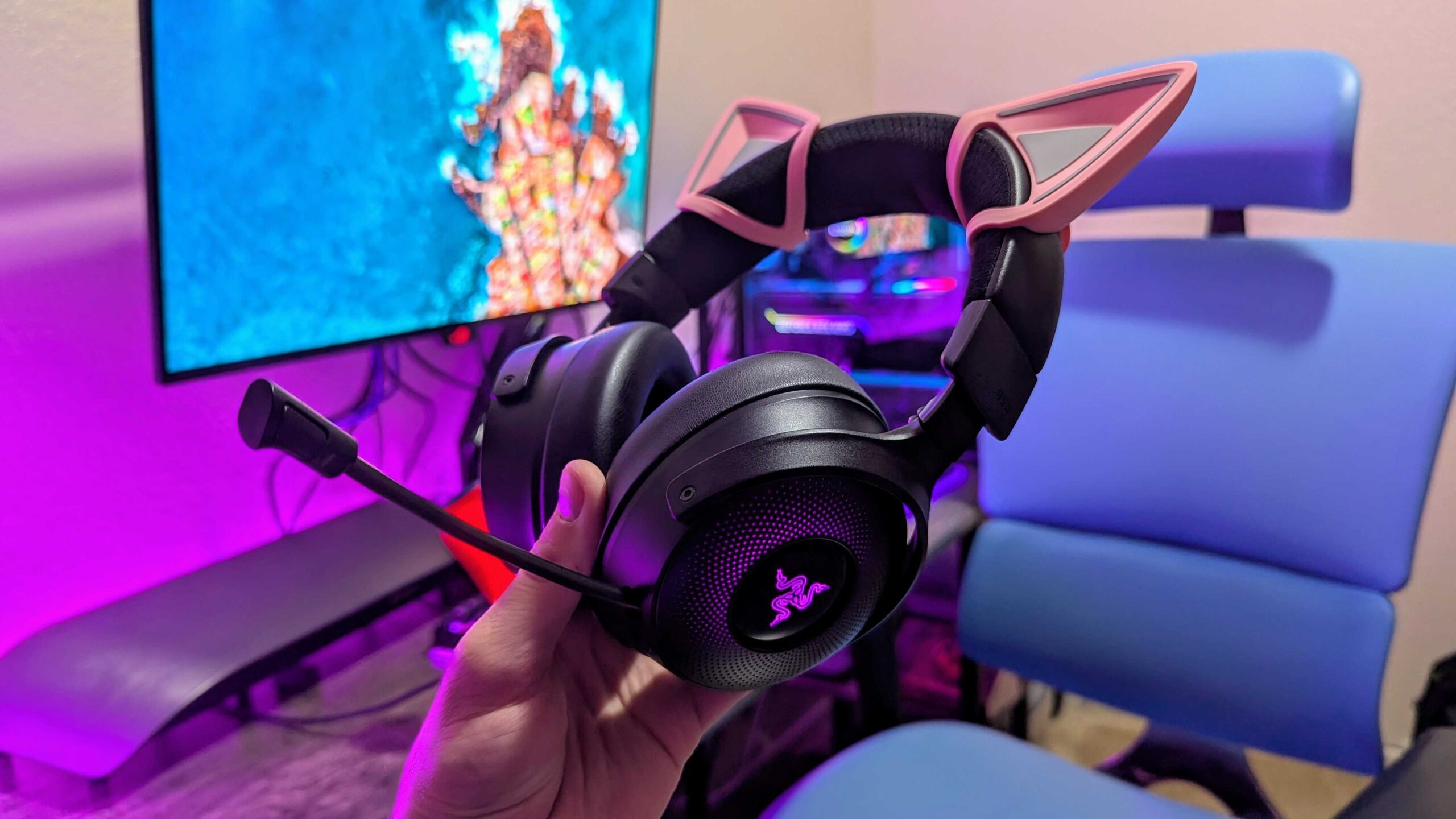 O Razer Kraken V4 Pro segurado por uma mão com o microfone estendido.