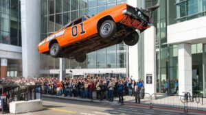 O General Lee fazendo um salto acrobático na frente de uma multidão em um prédio