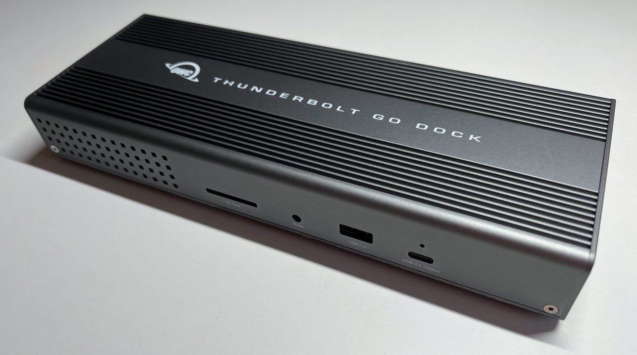 Thunderbolt Go Dock retangular com múltiplas portas, incluindo USB, áudio e slots para cartão SD, em um design elegante em cinza e preto.