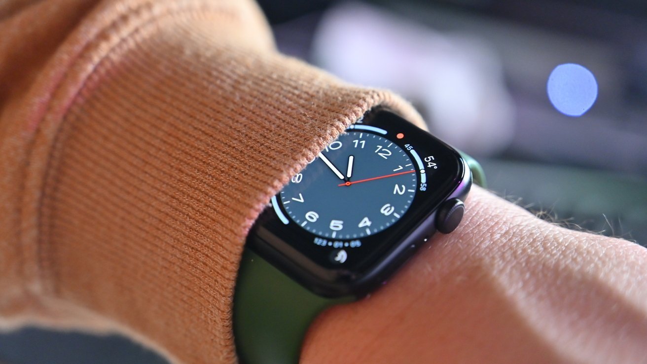 Apple Watch SE 2, parcialmente coberto por uma capa marrom no pulso.