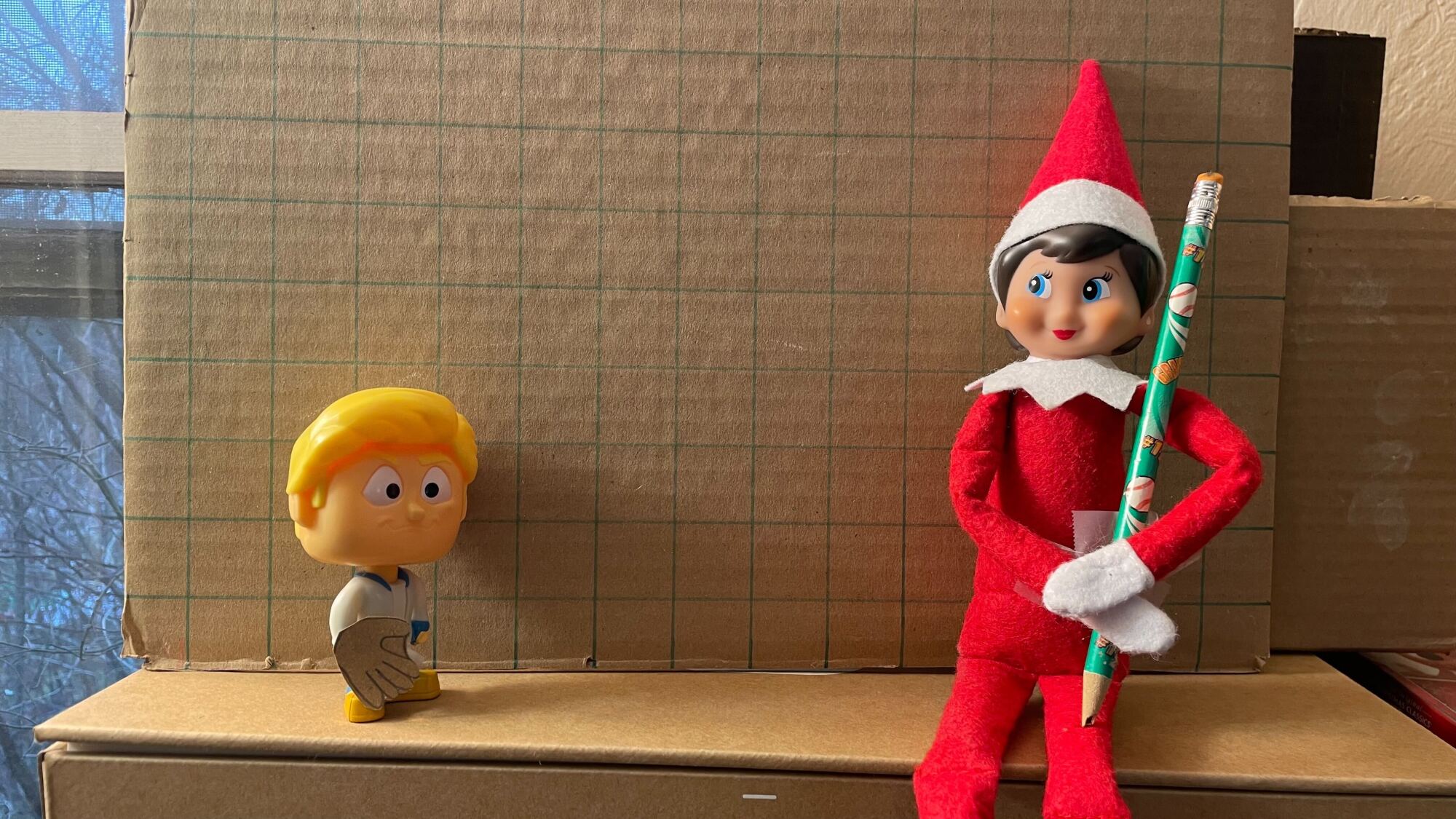 elfo e bobblehead. Elf está segurando um lápis... mais ou menos como um taco de beisebol?