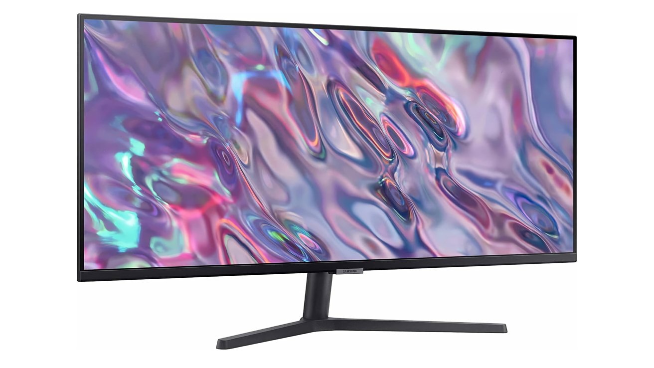 Monitor de tela plana exibindo um redemoinho vibrante e abstrato de cores, incluindo rosa, roxo, azul e verde, com um elegante suporte preto.