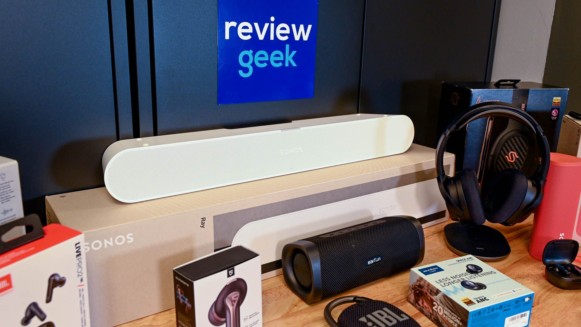 Coleção de produtos de áudio, incluindo soundbars e fones de ouvido, com o logotipo Review Geek.