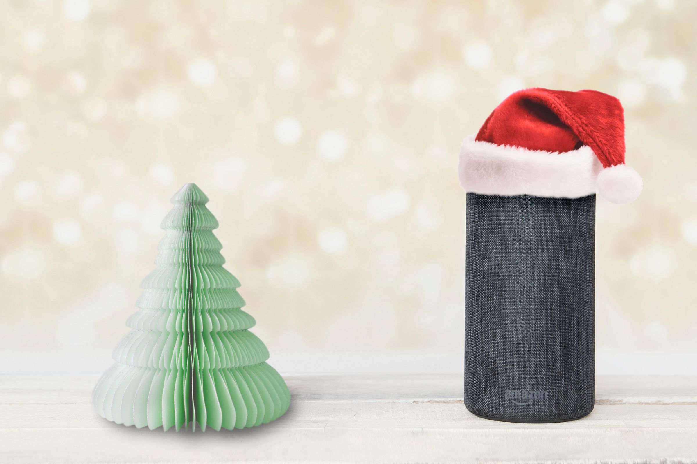 Amazon Alexa com chapéu de Papai Noel e árvore de Natal.