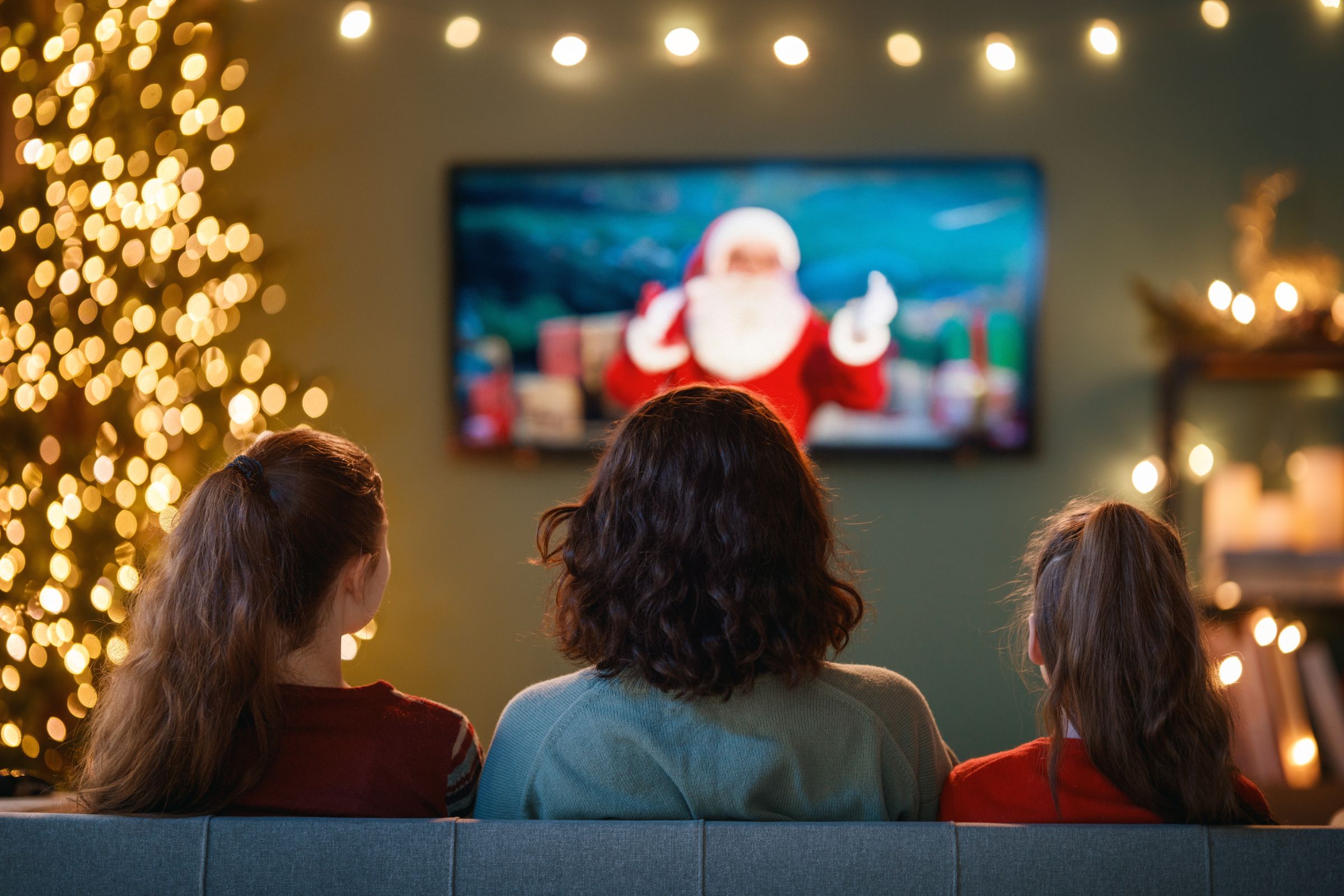 Família sentada em frente à TV no Natal.