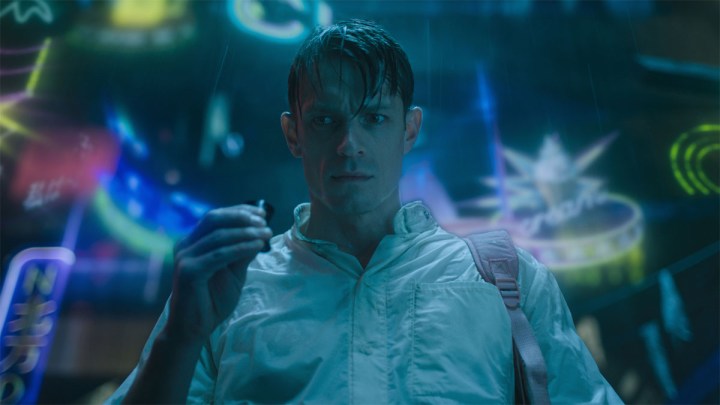 Joel Kinnaman senta em uma cadeira e toca a luz em Altered Carbon.