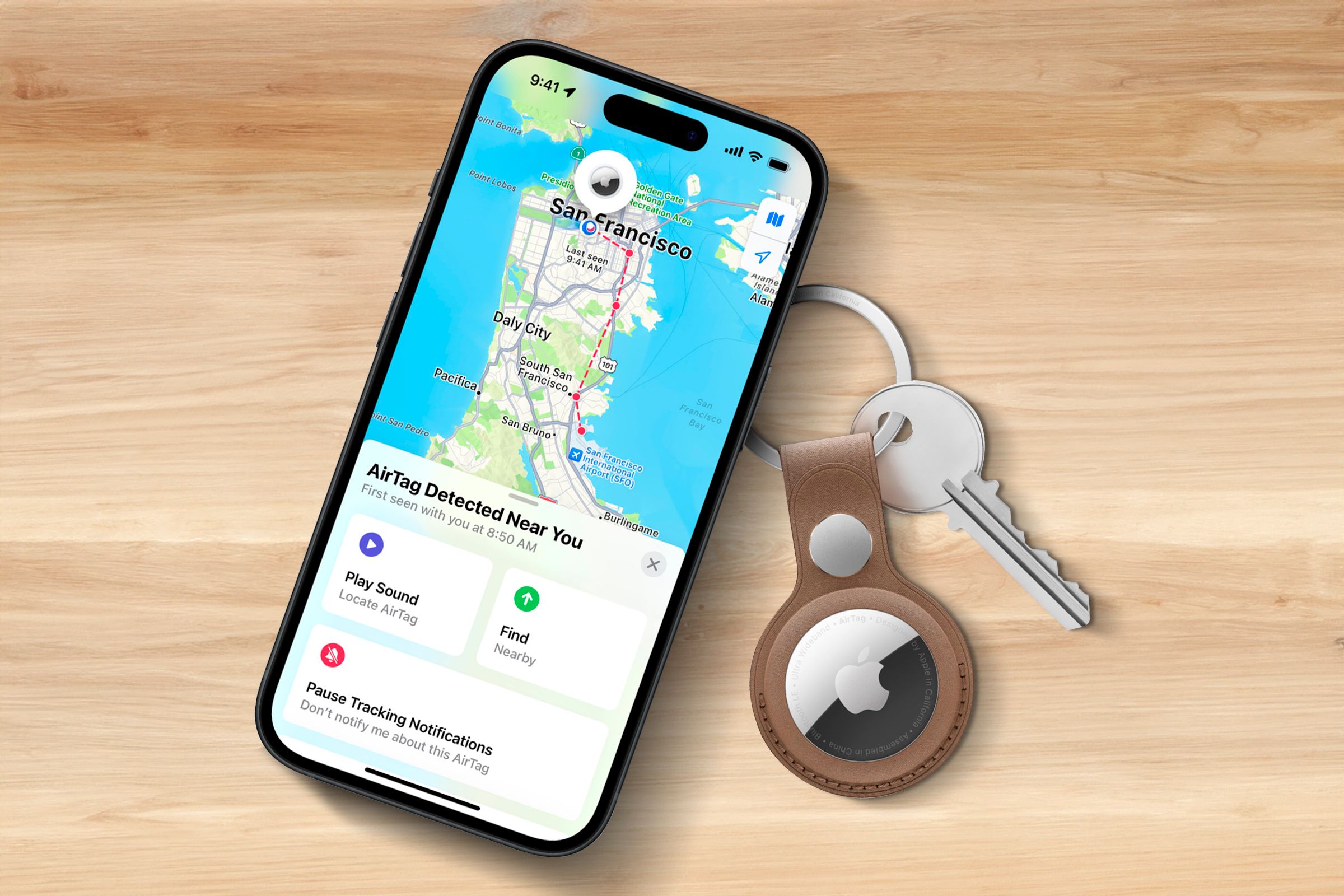 Um iPhone em uma superfície de madeira exibindo uma localização no mapa, com um AirTag próximo a ele.