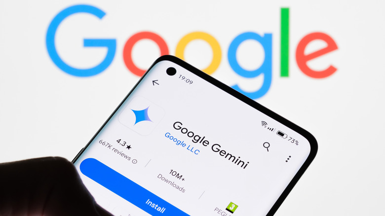 Uma pessoa instala o Google Gemini em seu smartphone em frente ao logotipo do Google