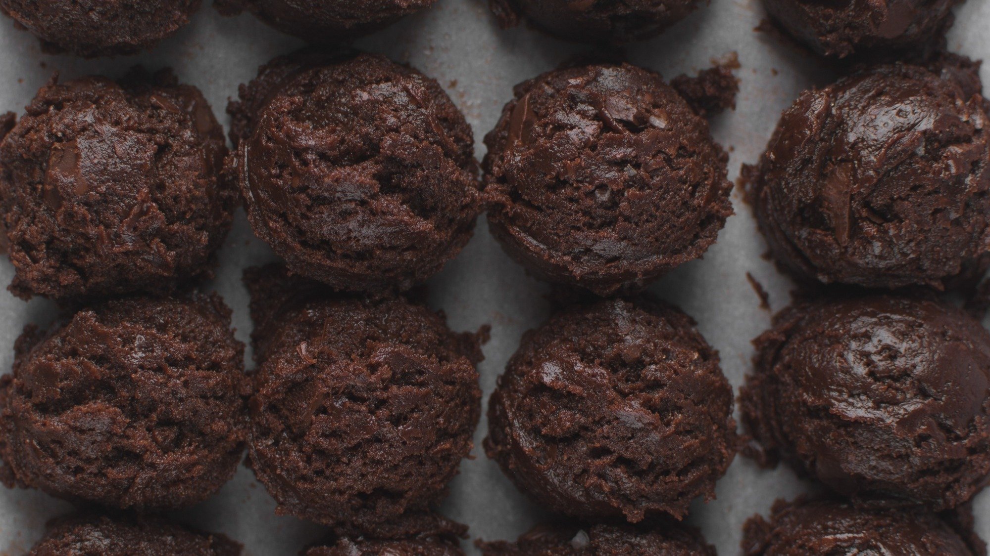 Bolas de massa de biscoito de chocolate colocadas em uma bandeja.