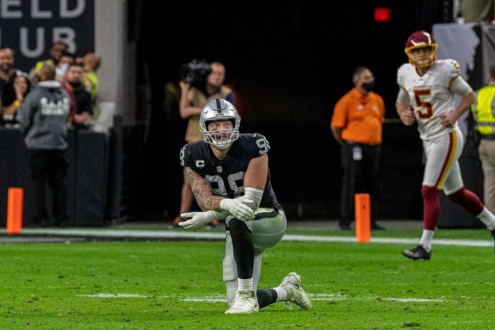 Maxx Crosby dá uma joelhada no campo de futebol com o Las Vegas Raiders.