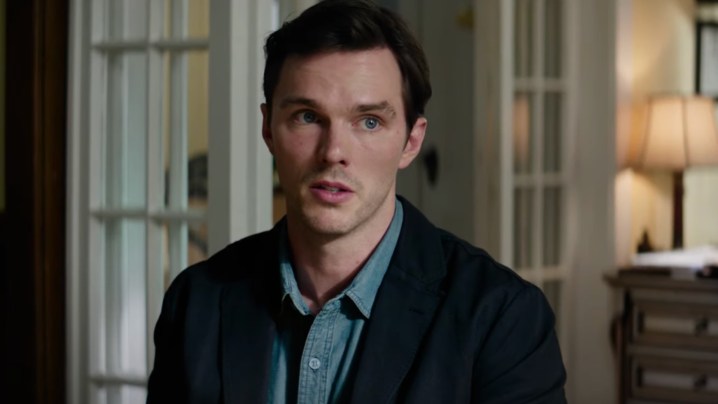 Nicholas Hoult se senta e parece preocupado.