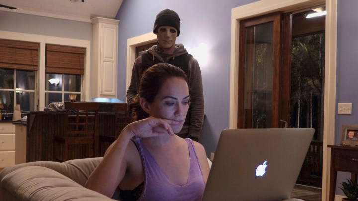 Um assassino mascarado observa Kate Siegel trabalhando em uma cena de "Silêncio."