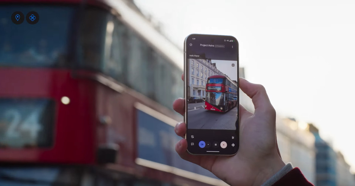 A photo of a person holding a phone up to a bus.