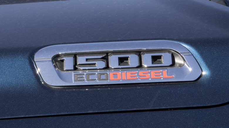 O emblema Ram 1500 EcoDiesel no capô de um caminhão Ram 1500 cinza.