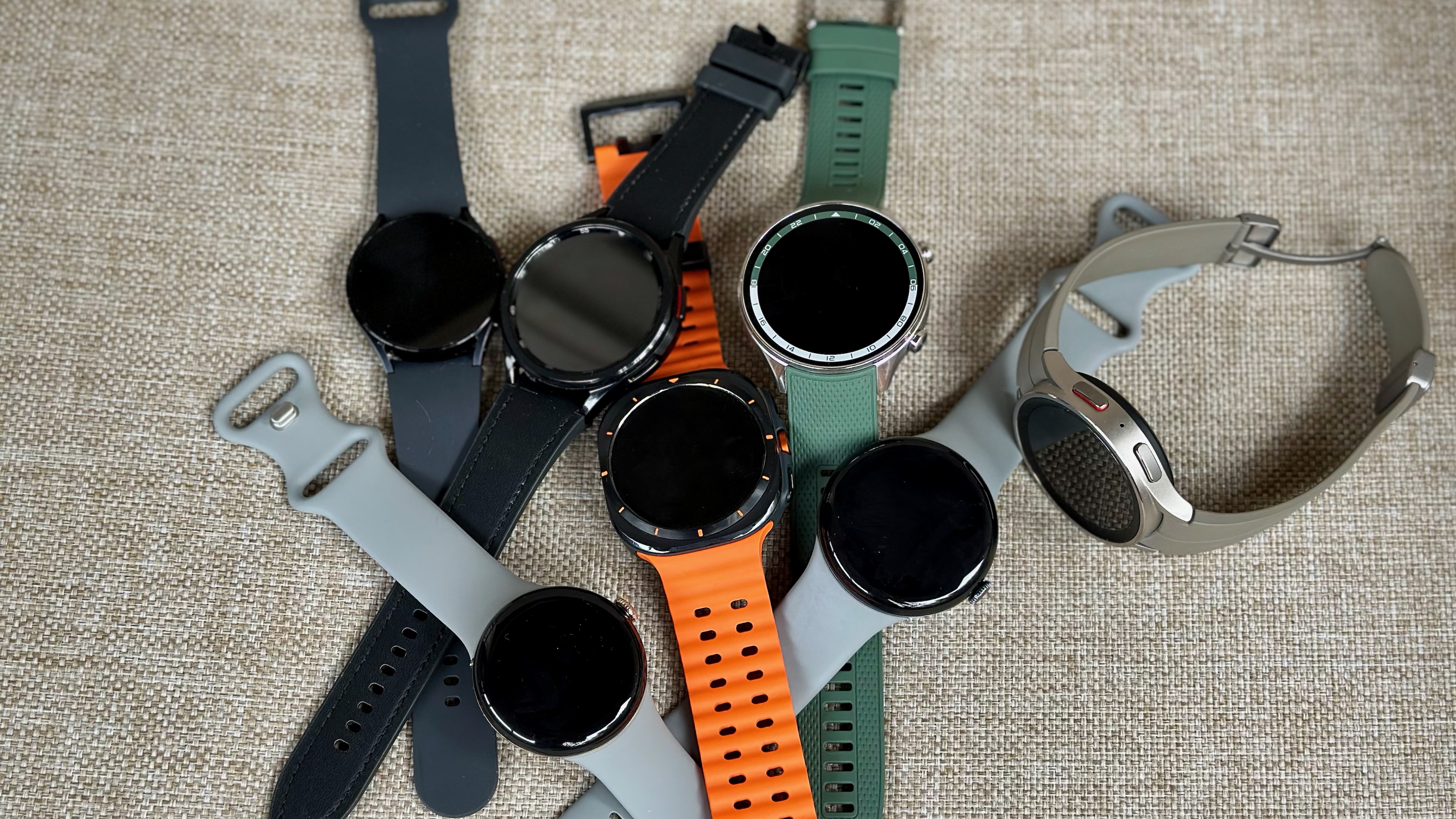 Uma pilha de relógios Wear OS: Samsung Galaxy Watch Ultra, 6, 6 Classic e 5 Pro; o Google Pixel Watch 3 e 2; e o OnePlus Watch 2R.