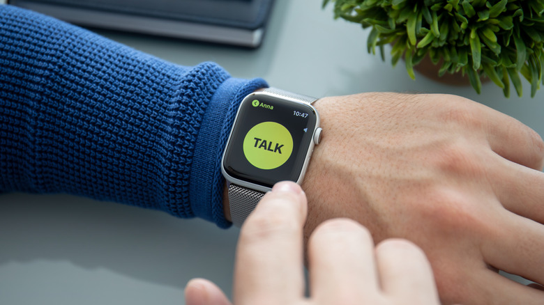 Braço de homem usando Apple Watch mostrando o botão push-to-talk do Walkie-Talkie