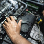 Mãos de mecânico consertando um carro em uma oficina mecânica