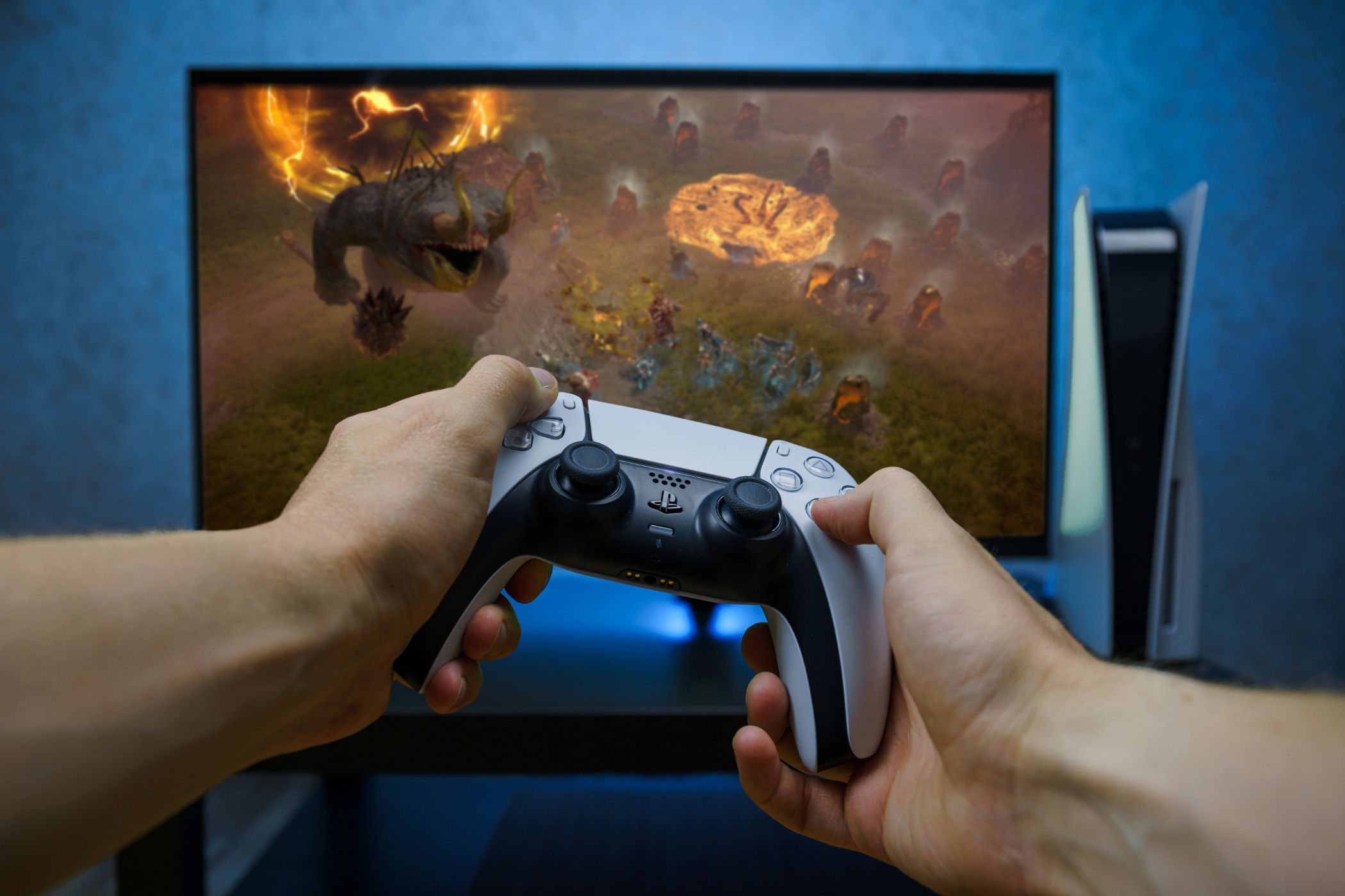 Controlador DualSense do PlayStation 5 na frente de um monitor de jogos.