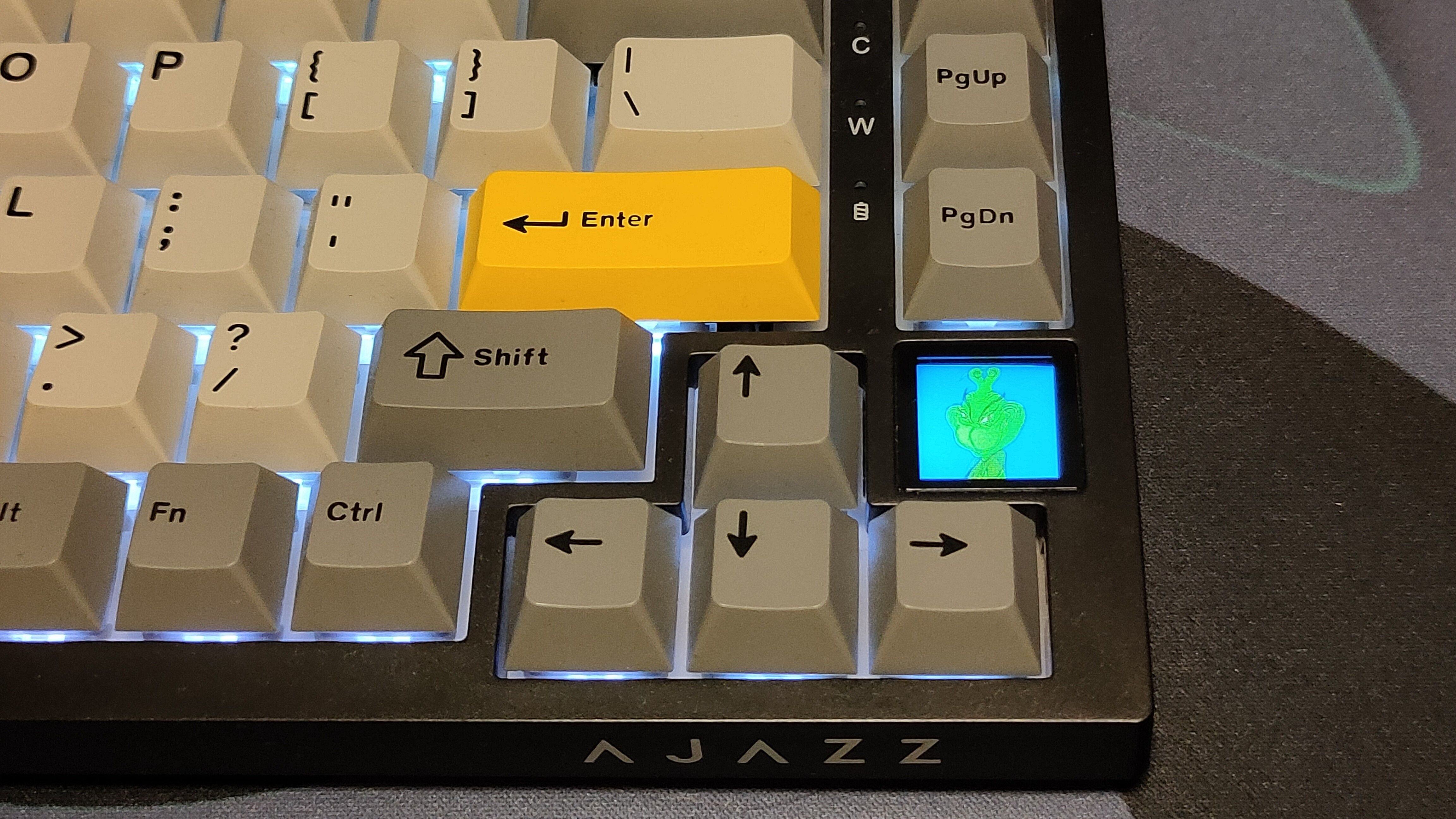 Um close do teclado Ajazz AK820 exibindo um GIF na tela integrada.