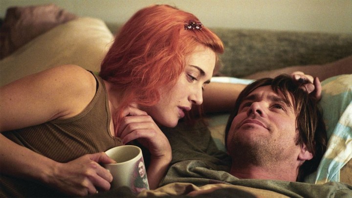 Kate Winslet e Jim Carrey abraçados em uma cama em "Brilho Eterno da Mente Sem Lembranças."