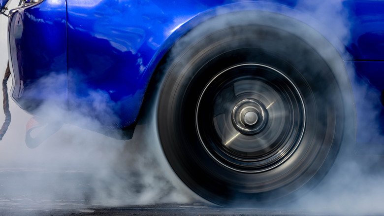 Close da roda do dragster fazendo um burnout