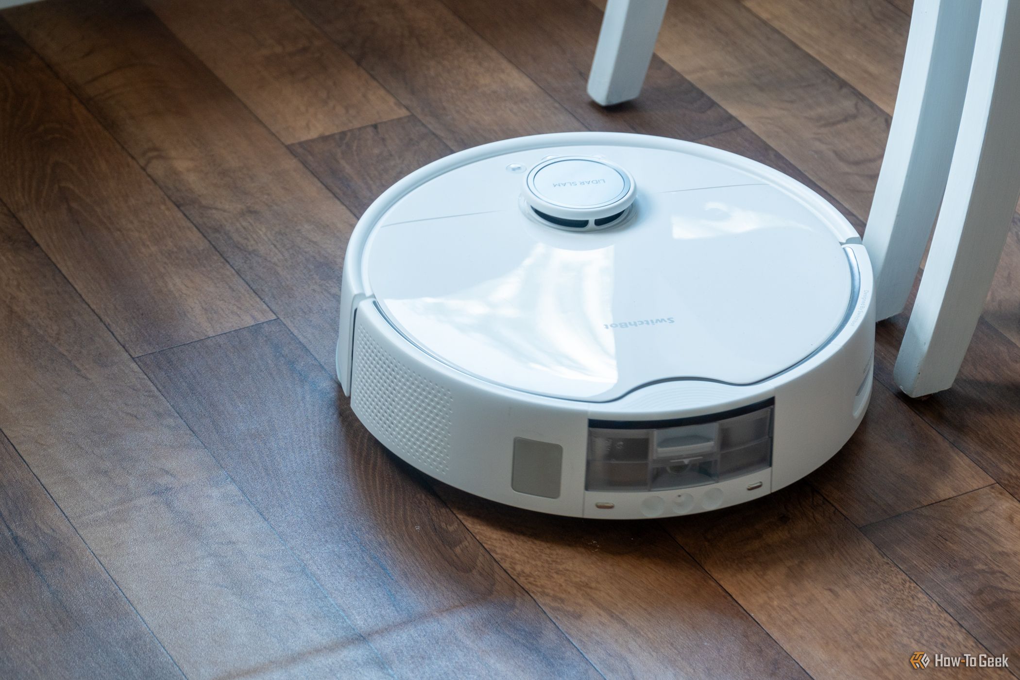 SwitchBot S10 Robot Vacuum contornando uma cadeira.