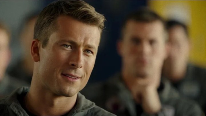 Glen Powell olha e sorri em Top Gun: Maverick.