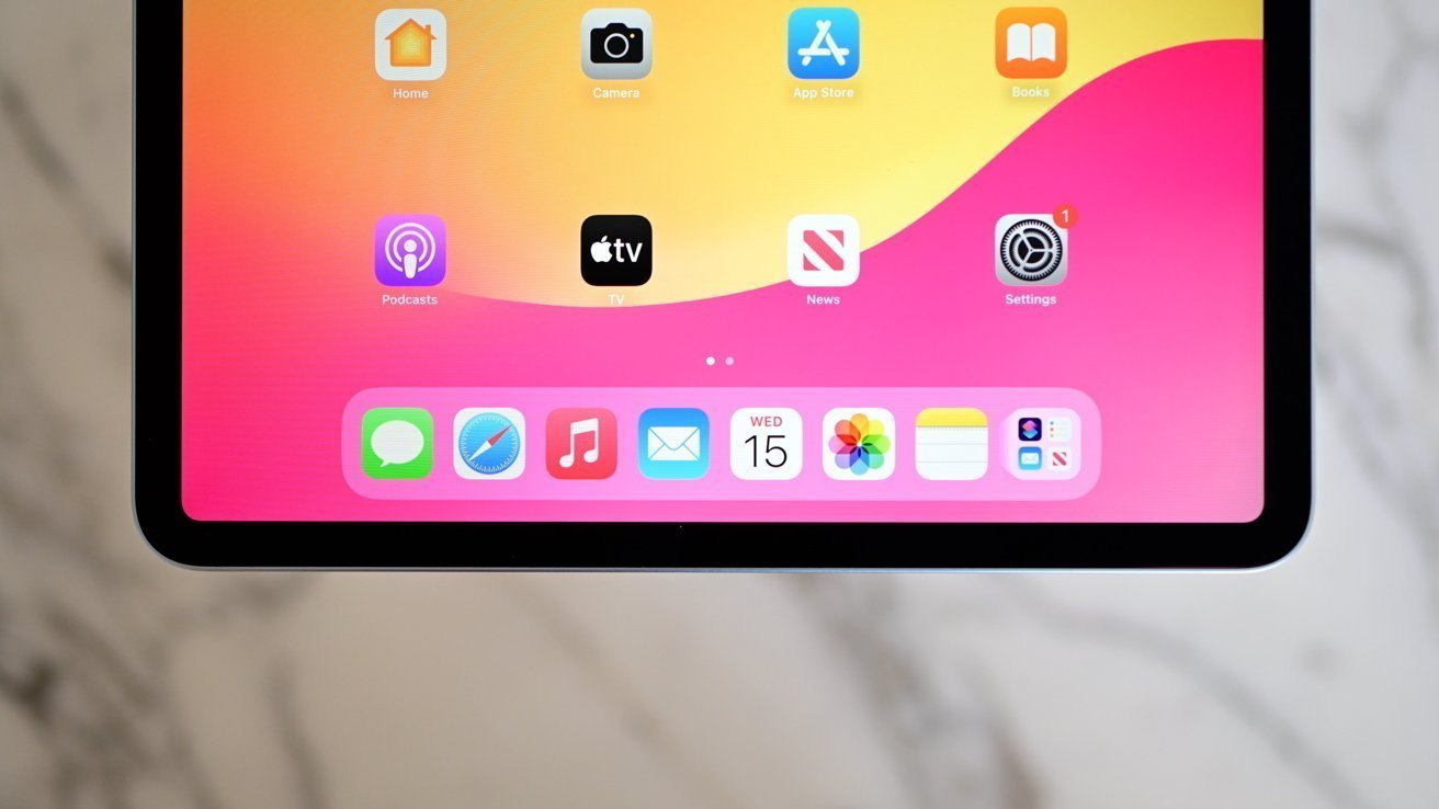 Tela do tablet mostrando ícones de aplicativos contra um fundo gradiente rosa e amarelo vibrante, incluindo aplicativos Mensagens, Safari, Música e Mail. Cantos arredondados e design elegante.