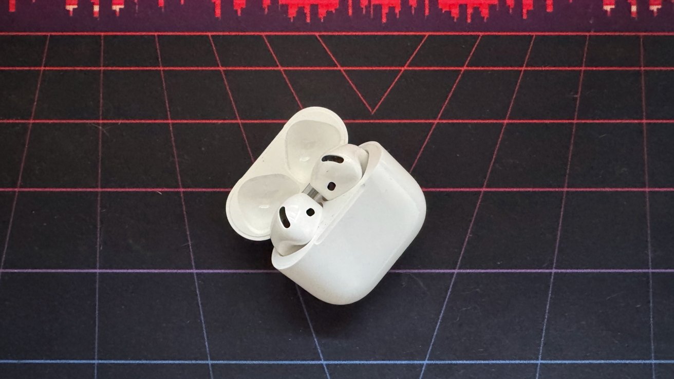 AirPods 4 no estojo de carregamento aberto em uma mesa.