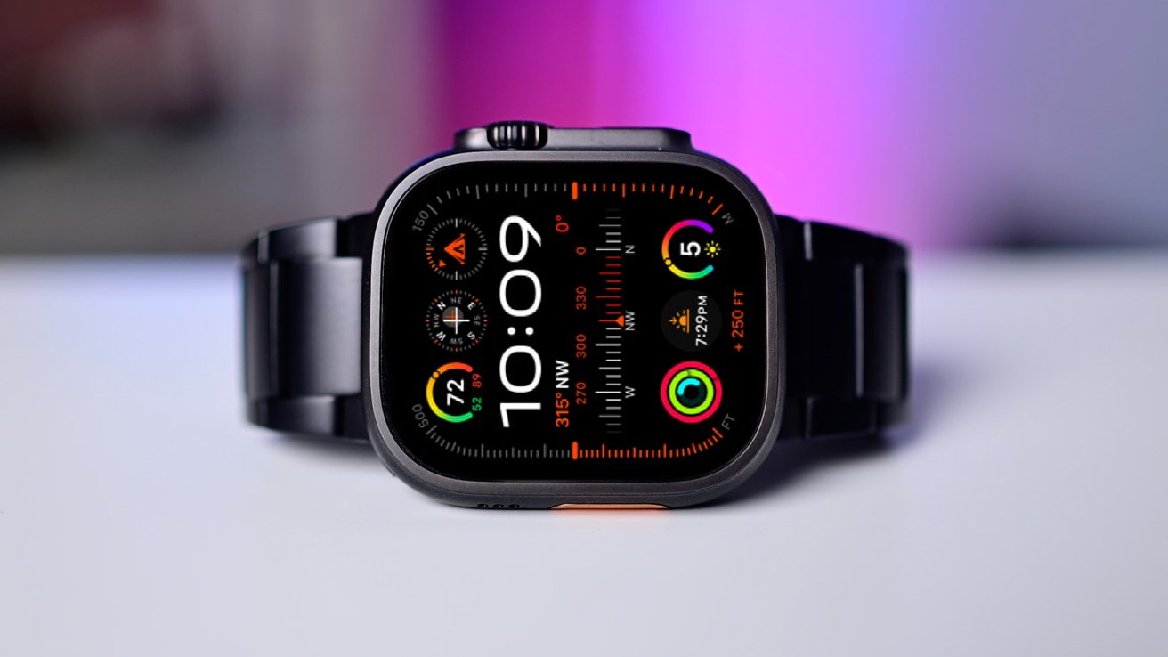 Smartwatch com faixa preta, display colorido brilhante mostrando tempo, bússola e anéis de atividade contra um fundo desfocado roxo e azul.