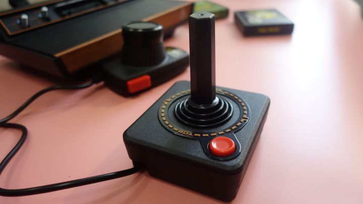 Um joystick Atari 2600+ está sobre uma mesa.