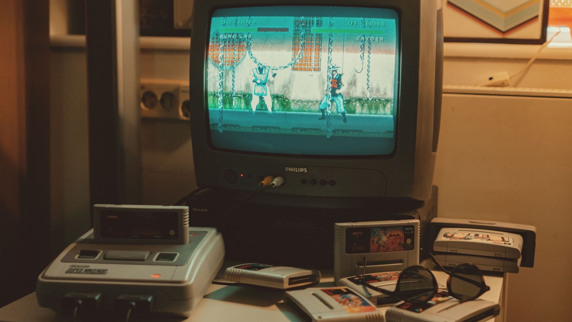 Um Nintendo SNES conectado a uma TV CRT, rodeado de cartuchos de jogos.