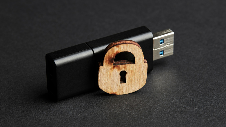 Stick USB preto com fechadura de madeira sobre fundo fosco